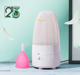 دستگاه استرلایزر با زمینه سازمانی سبز رنگ و یک کاپ صورتی در کنارش