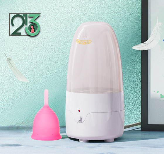 دستگاه استرلایزر با زمینه سازمانی سبز رنگ و یک کاپ صورتی در کنارش