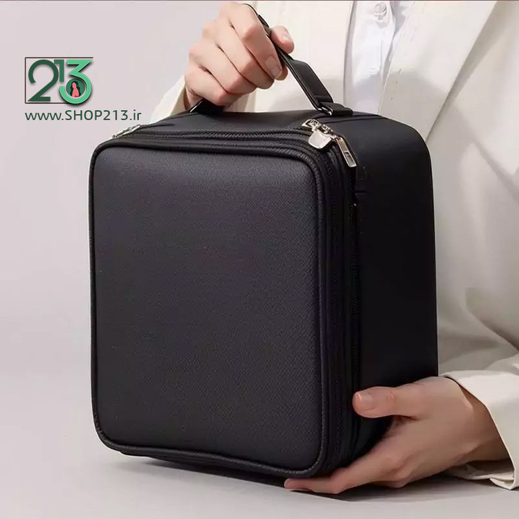 دو دست یک خانم با لباس سفید که کیف آرایشی مشکی مسافرتی رو دست گرفته