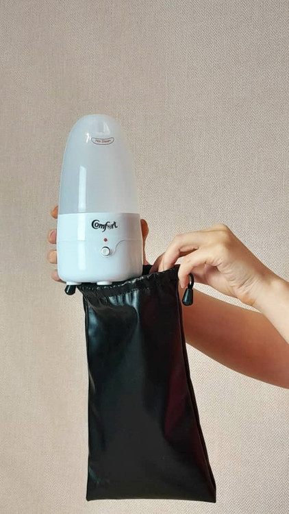 دستی که دستگاه استرلایزر رو داخل کیف چرمی میگذارد