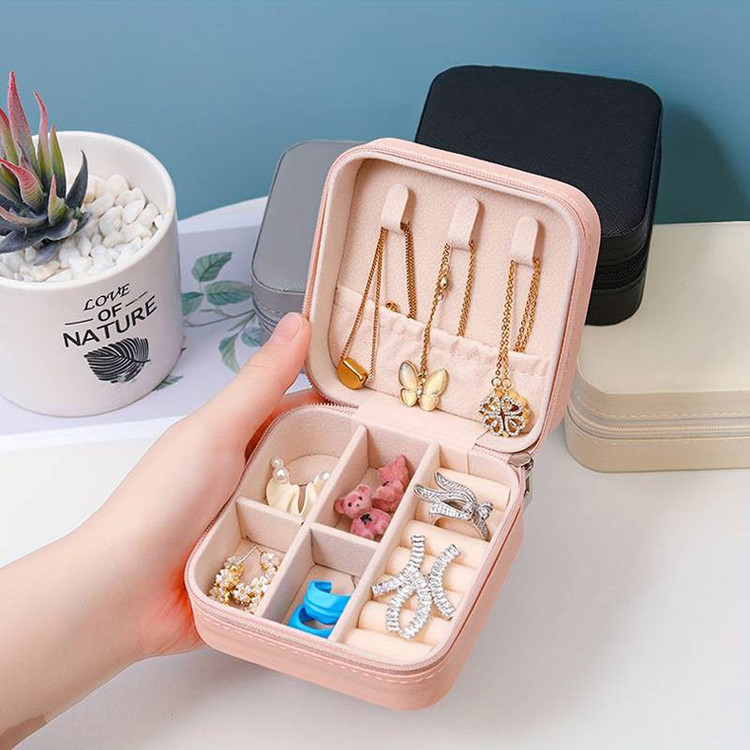 دستی که جعبه جواهرات باز شده رو نگه داشته و زیورآلات در آن نشان داده شده