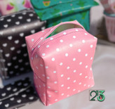 کیف پد صورتی خال خال سفید که رنگ مشکی در پشت تصویر قرار دارد