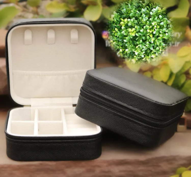 دو عدد جعبه جواهرات مشکی که یکی درب باز و دیگری به صورت اریب روی آن قرار گرفته