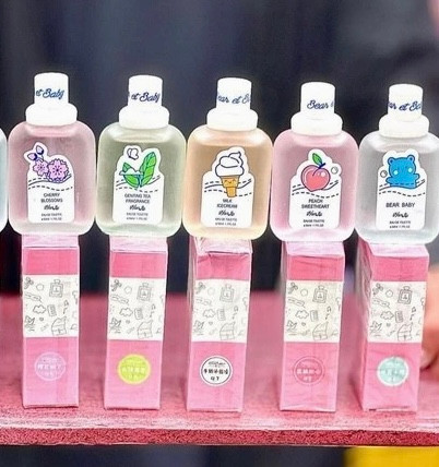 ۵مدل از عطر های بیکینی با رایحه های مختلف و رنگبندی مختلف ایستاده روی جعبه هاشون